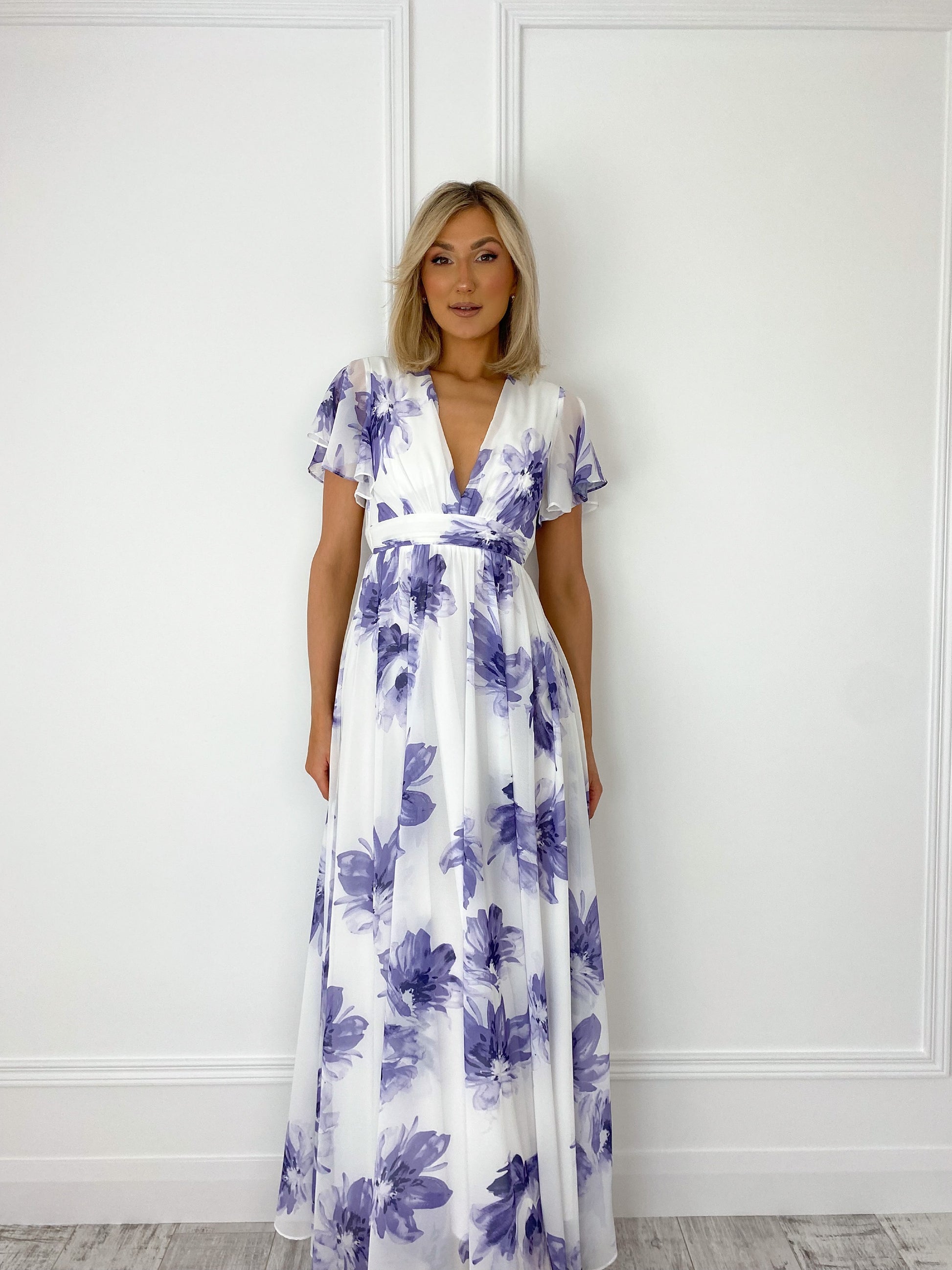 a woman in a white dress standing in front of a door