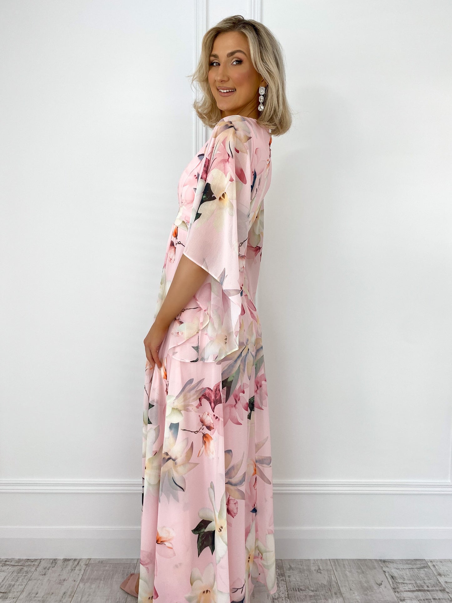 a little girl in a pink dress holding a pink umbrella
