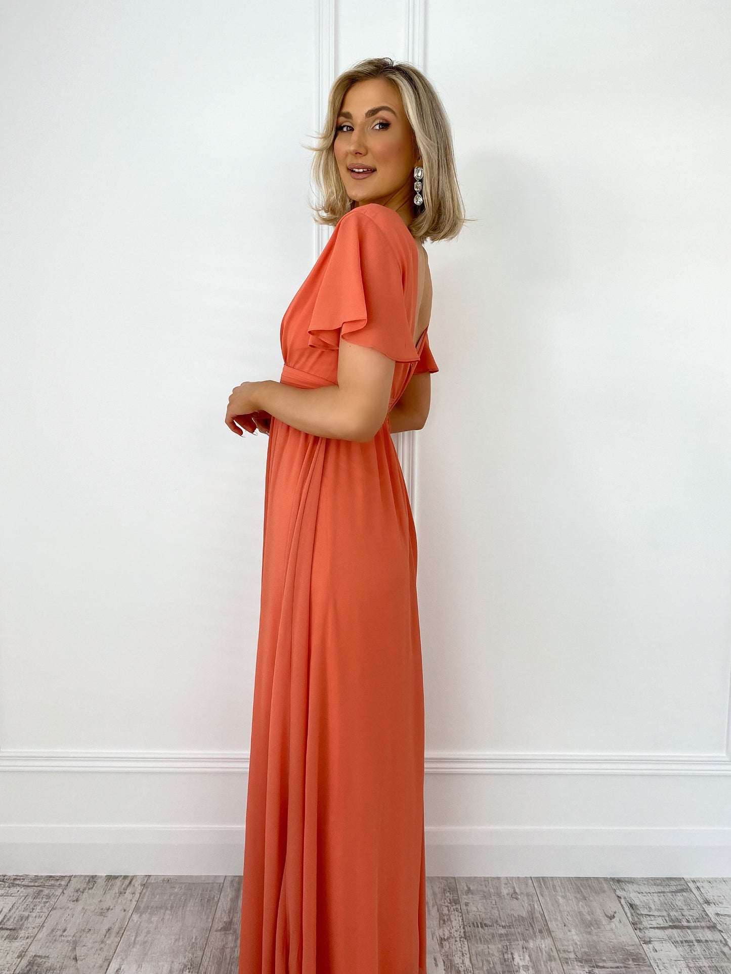 a woman in a red dress standing in front of a building