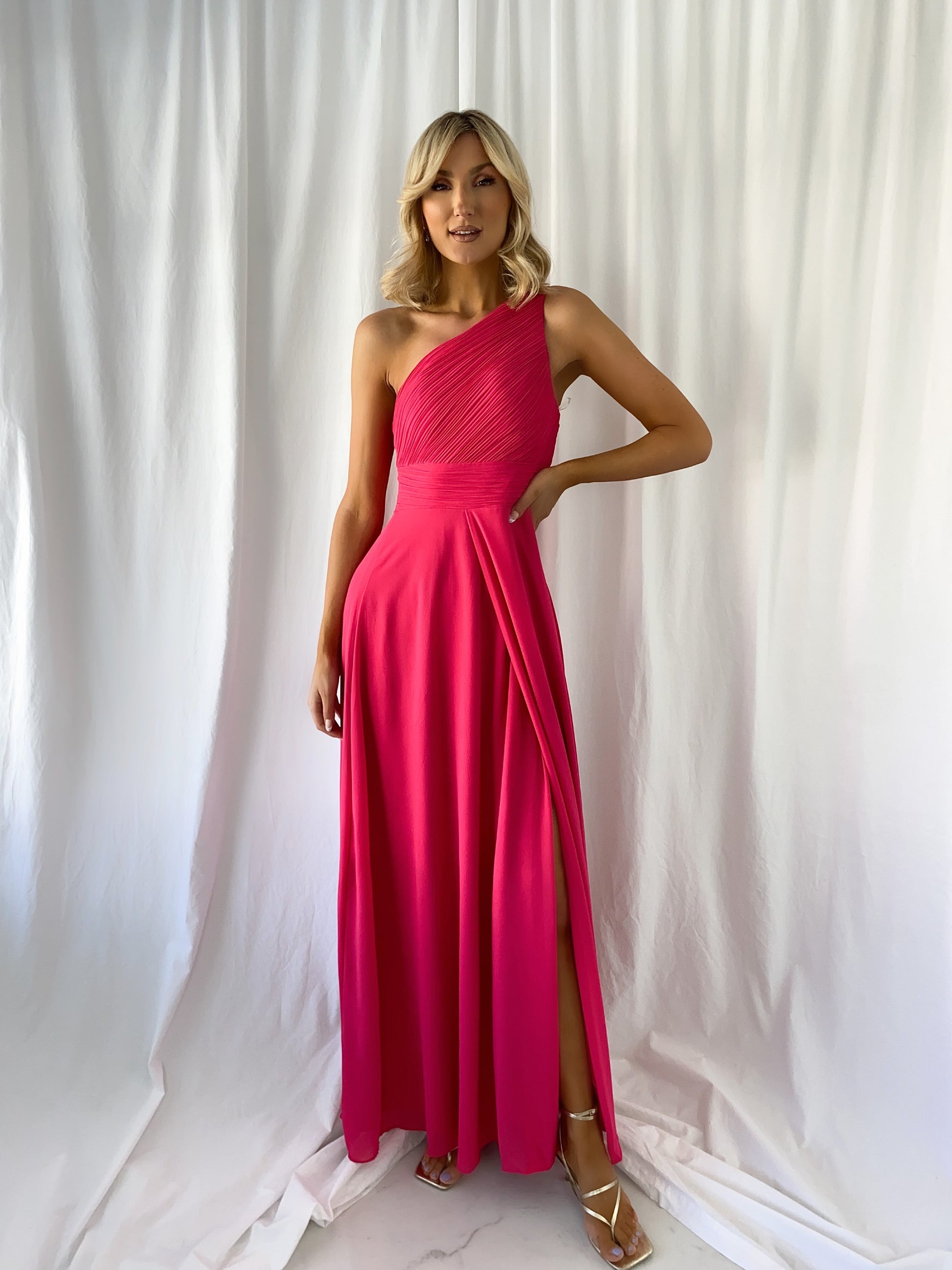 a woman in a red dress standing in front of a curtain 