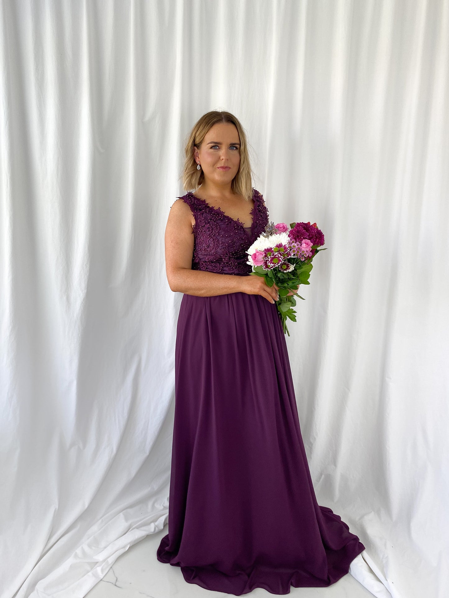 a woman in a pink dress holding a flower 