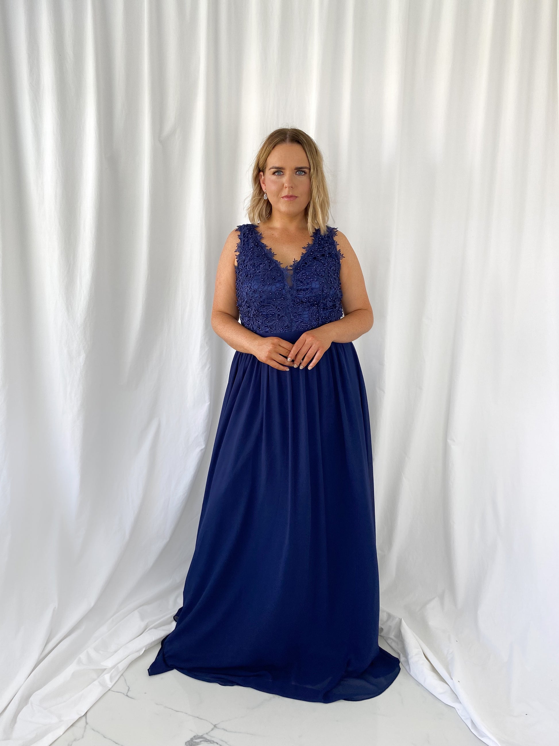 a woman in a blue dress standing in a white dress 