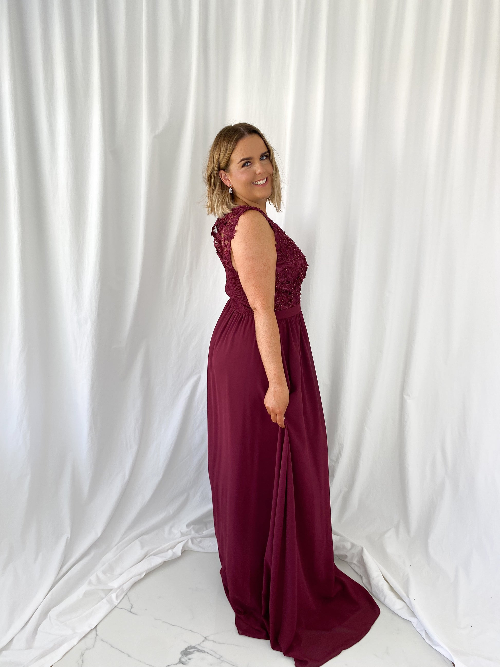 a woman in a red dress talking on a cell phone 