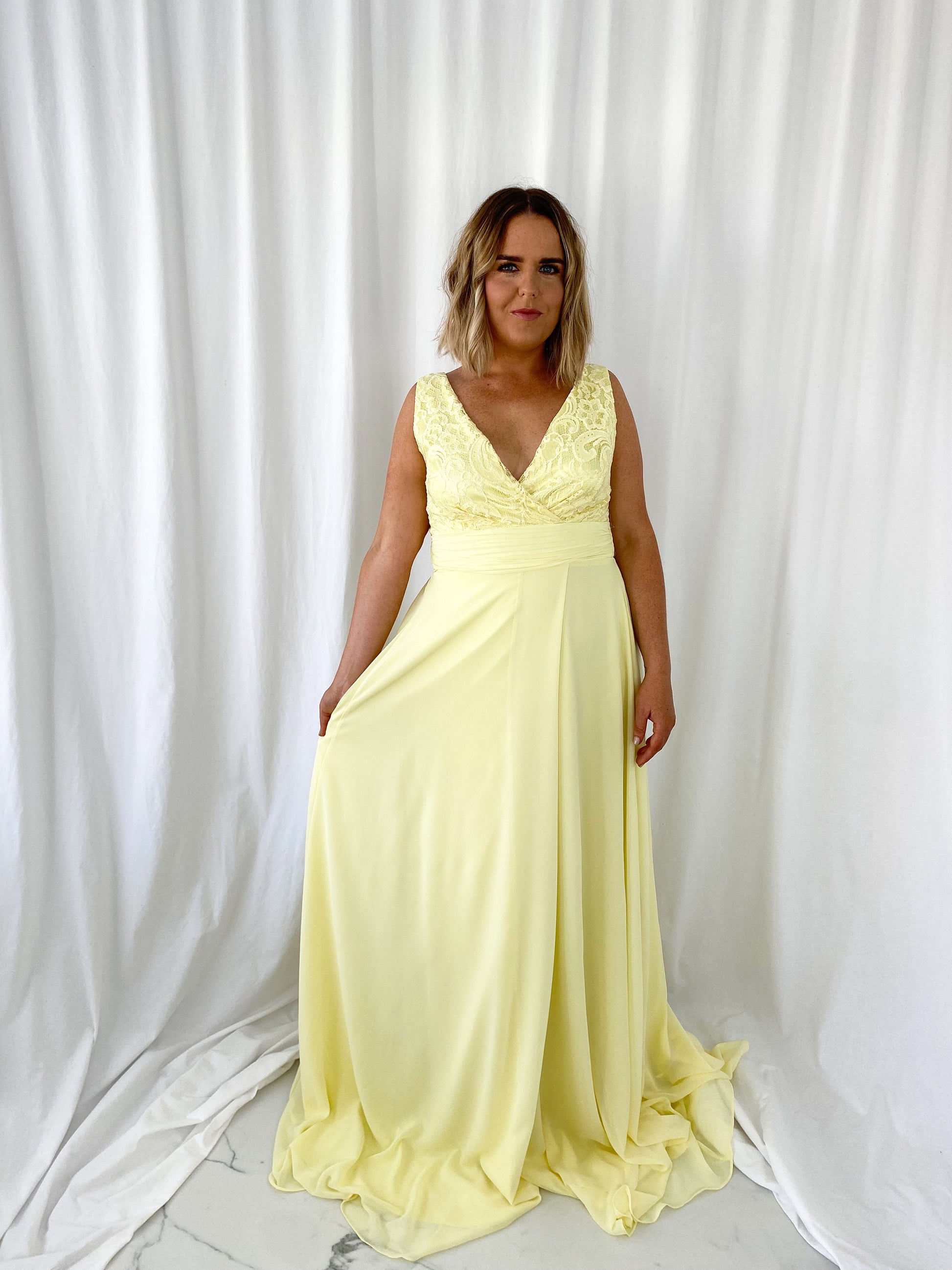 a woman in a yellow dress standing in a white dress 