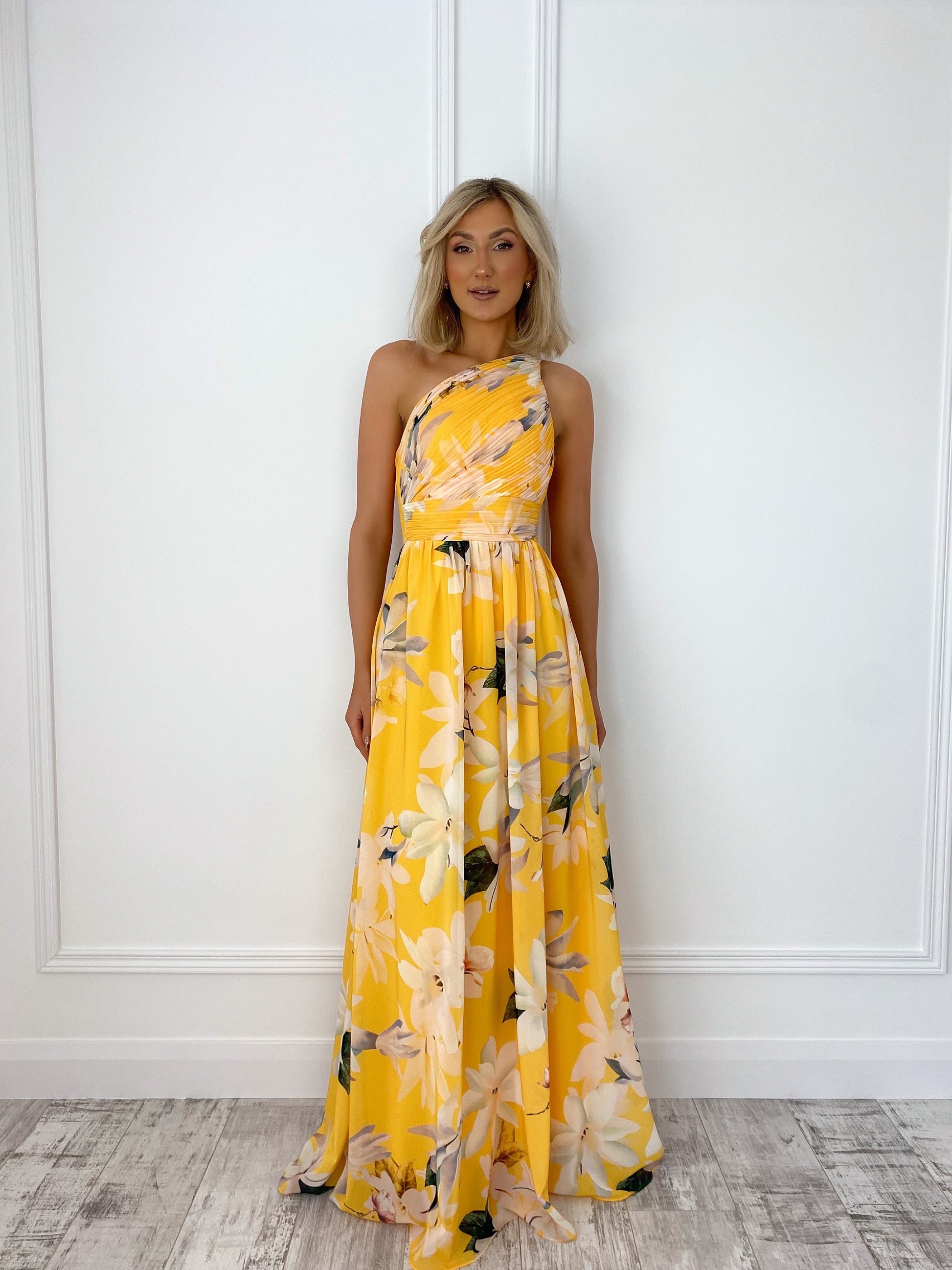 a woman in a yellow dress standing in front of a door 