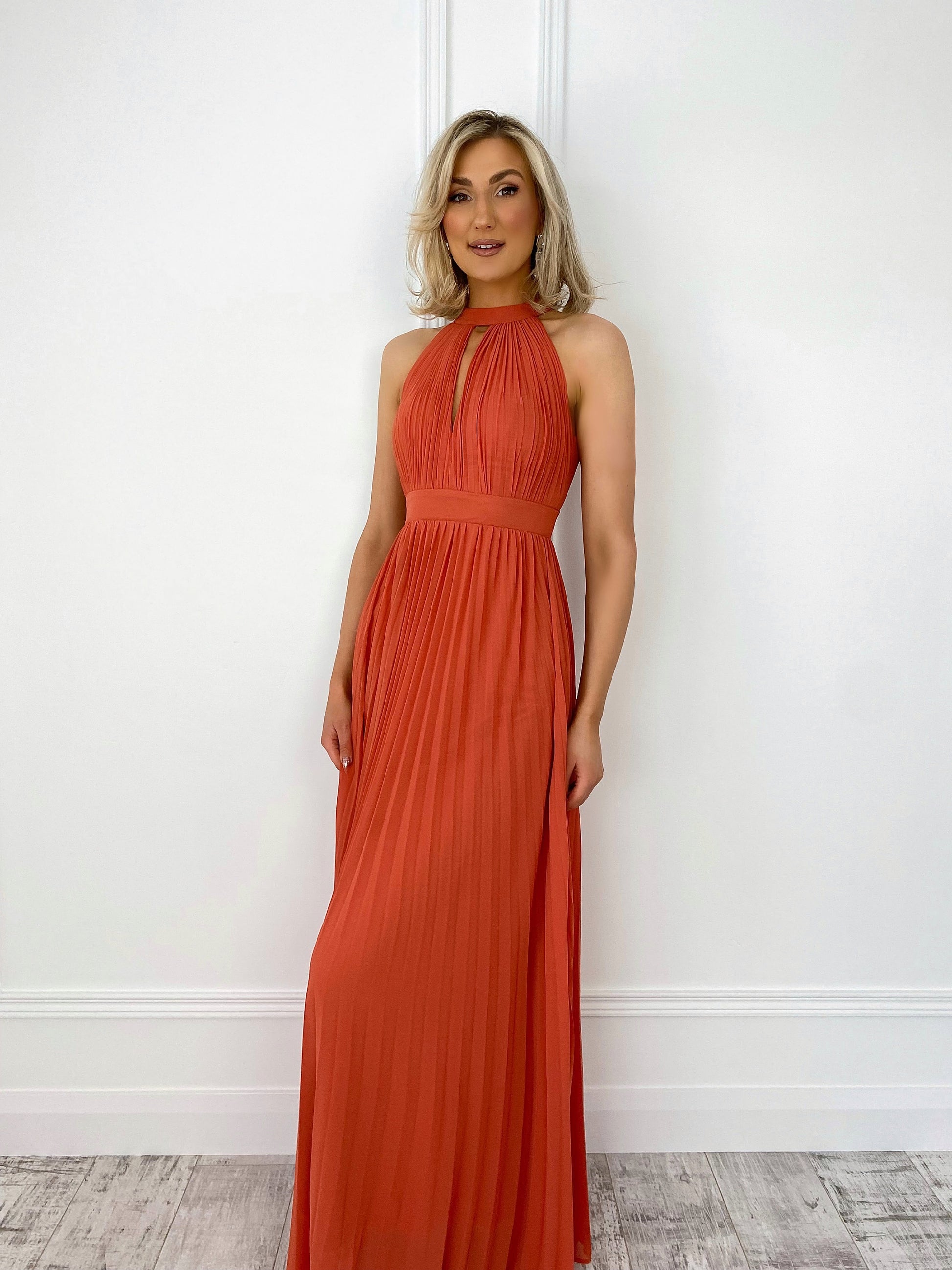 a woman in a red dress standing in front of a wall 